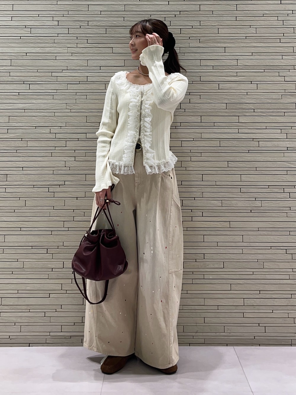 ホワイト系のカーディガン/ボレロ、ベージュ系のその他パンツ、レッド系のトートバッグを着用したレディースの秋コーディネートの1枚目の写真