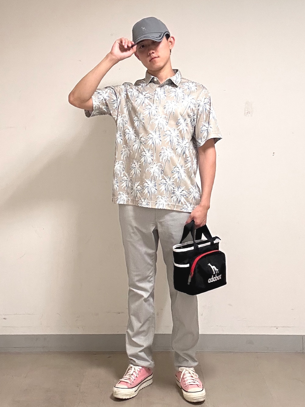 ホワイト系のポロシャツ、グレー系のその他パンツ、ブラック系のトートバッグを着用したメンズの夏コーディネートの1枚目の写真