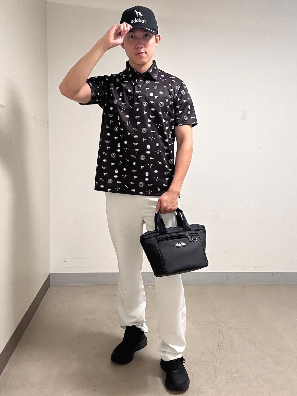ブラウン系のポロシャツ、グレー系のその他パンツ、ブラック系のキャップを着用したメンズの夏コーディネートの1枚目の写真