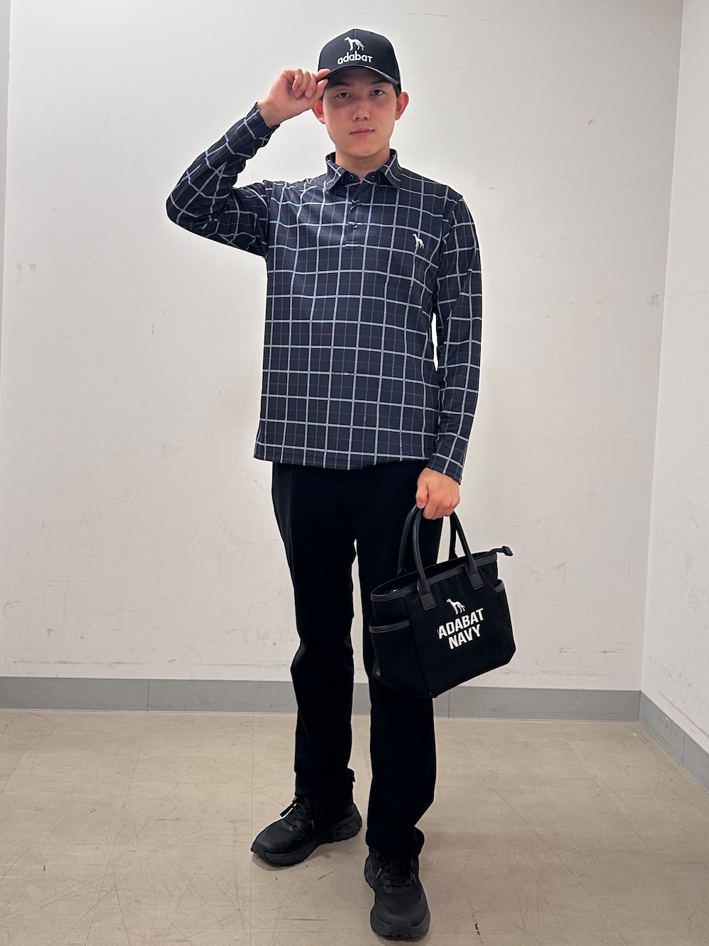 ブルー系のポロシャツ、ブラック系のその他パンツ、ブラック系のトートバッグを着用したメンズの秋コーディネートの1枚目の写真