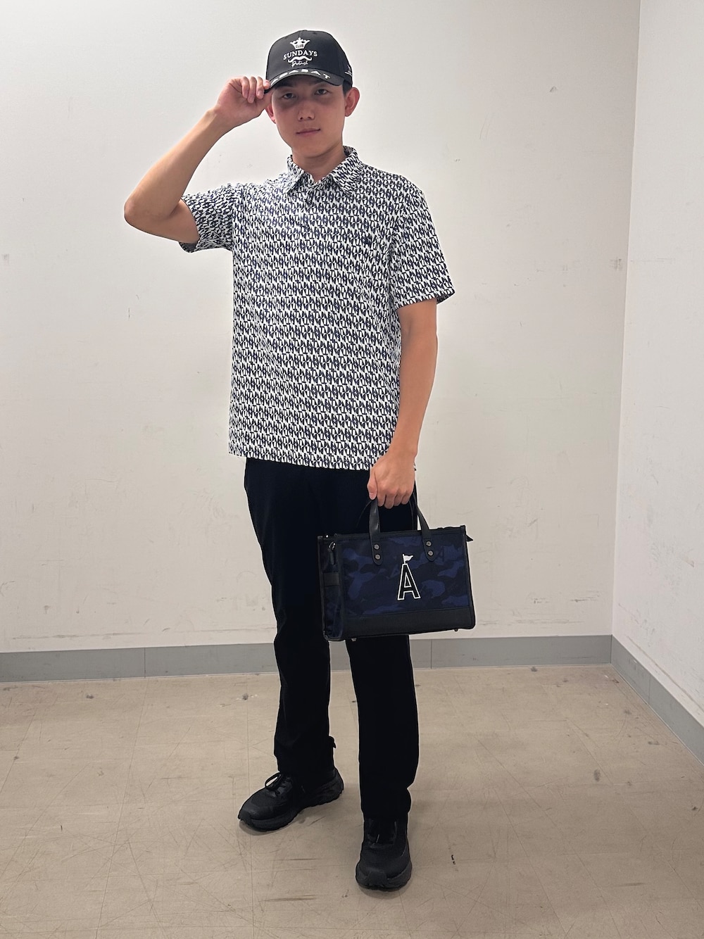 ブルー系のポロシャツ、ブラック系のその他パンツ、ブルー系のトートバッグを着用したメンズの夏コーディネートの1枚目の写真