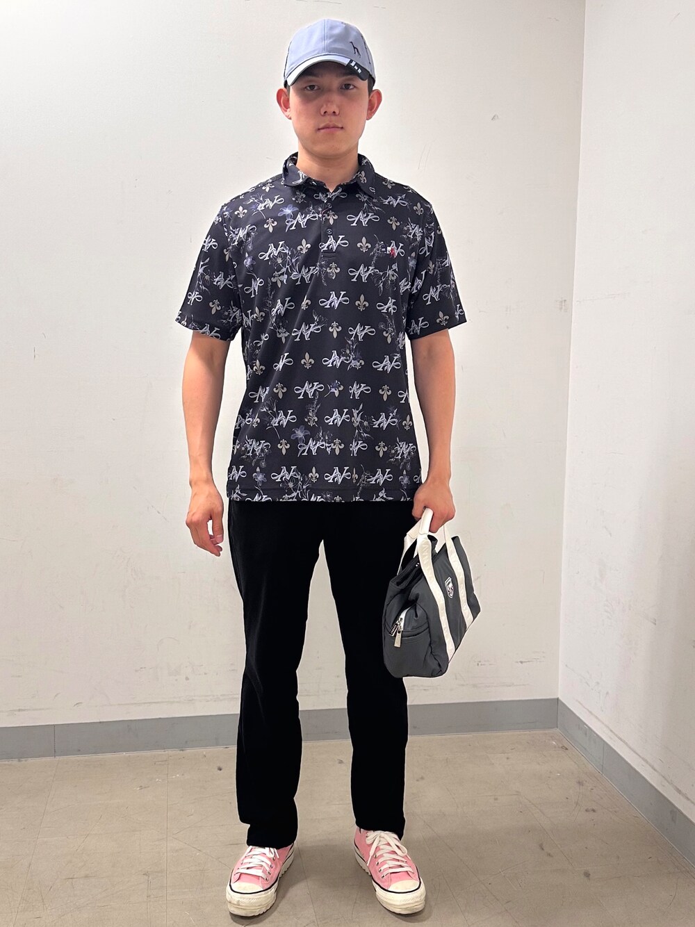 ブルー系のポロシャツ、ブラック系のその他パンツ、グレー系のキャップを着用したメンズの夏コーディネートの1枚目の写真