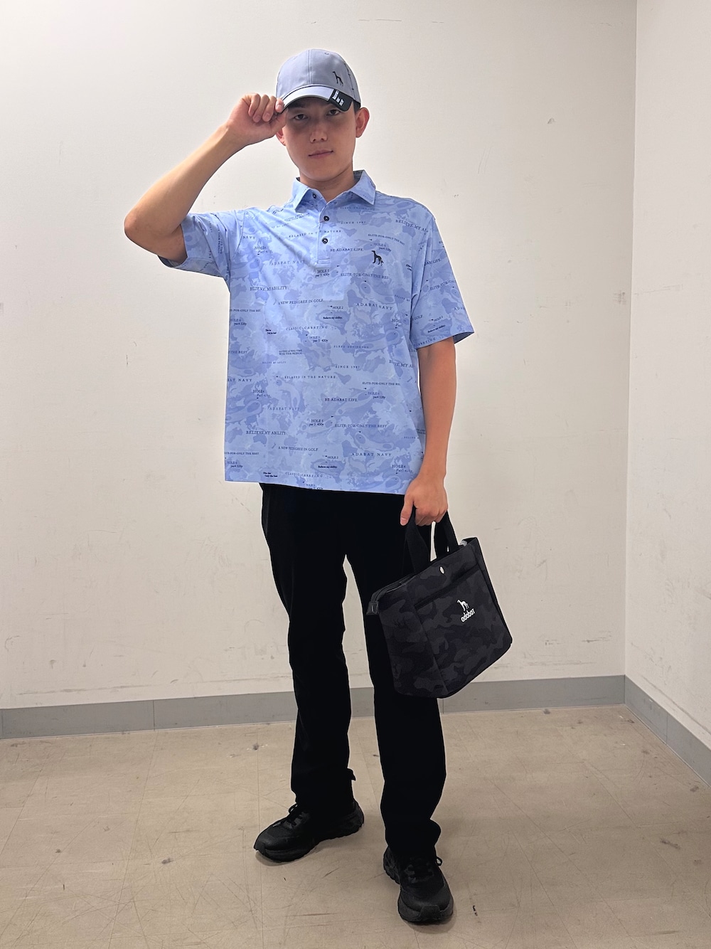 ブルー系のポロシャツ、ブラック系のその他パンツ、ブラック系のトートバッグを着用したメンズの夏コーディネートの1枚目の写真