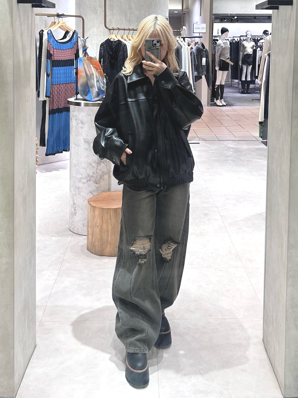 グレー系のデニムパンツ、ブラック系のブルゾン、グレー系のニット/セーターを着用したレディースの春コーディネートの1枚目の写真