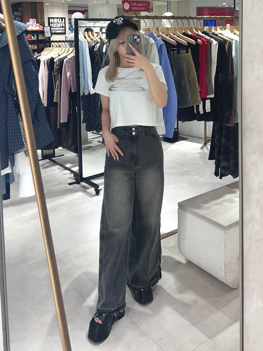 ブラック系のデニムパンツ、ブラック系のブーツ、ホワイト系のTシャツ/カットソーを着用したレディースの春コーディネートの1枚目の写真