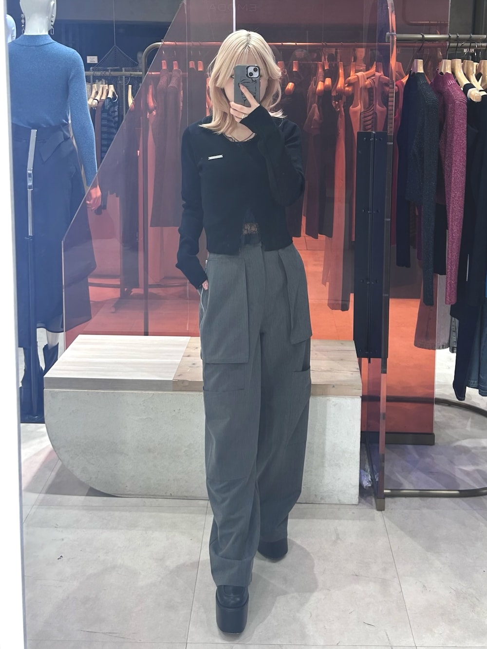 ブラック系のニット/セーター、グレー系のカーゴパンツ、ブラック系のブーツを着用したレディースの春コーディネートの1枚目の写真