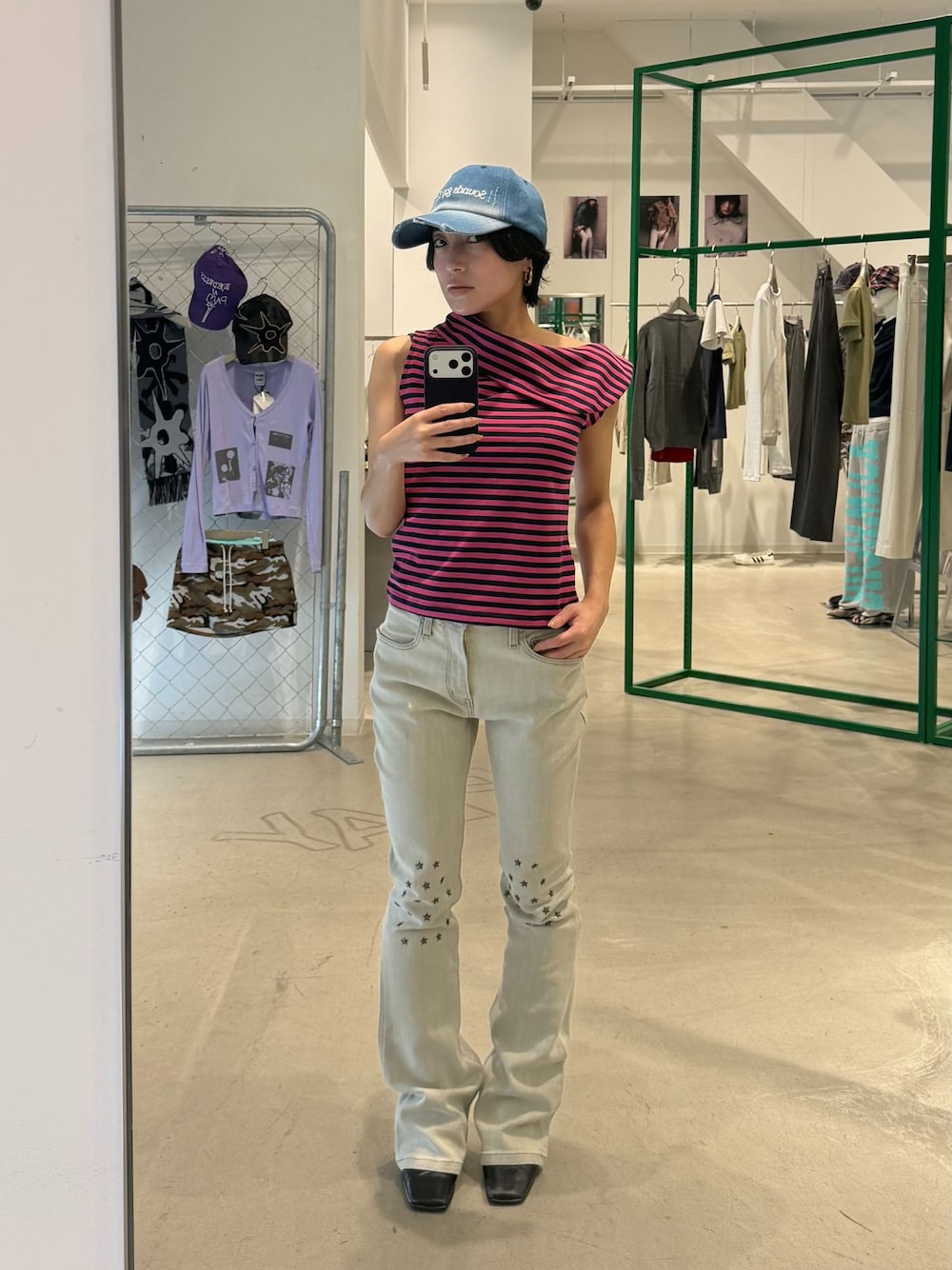 ベージュ系のデニムパンツ、グリーン系のTシャツ/カットソー、ブルー系のキャップを着用したレディースの秋コーディネートの1枚目の写真