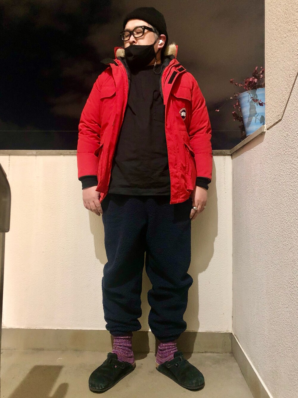 レッド系のダウンジャケット/コート、ブラック系のTシャツ/カットソー、ブラック系のサンダルを着用したメンズの冬コーディネートの1枚目の写真