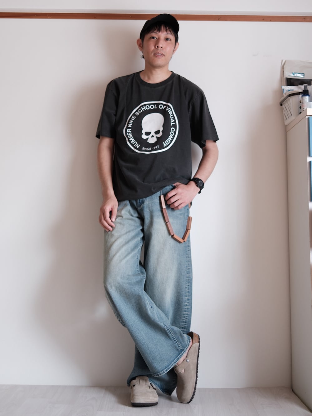 ブラック系のTシャツ/カットソー、ブルー系のデニムパンツ、ベージュ系のサンダルを着用したメンズの春コーディネートの1枚目の写真