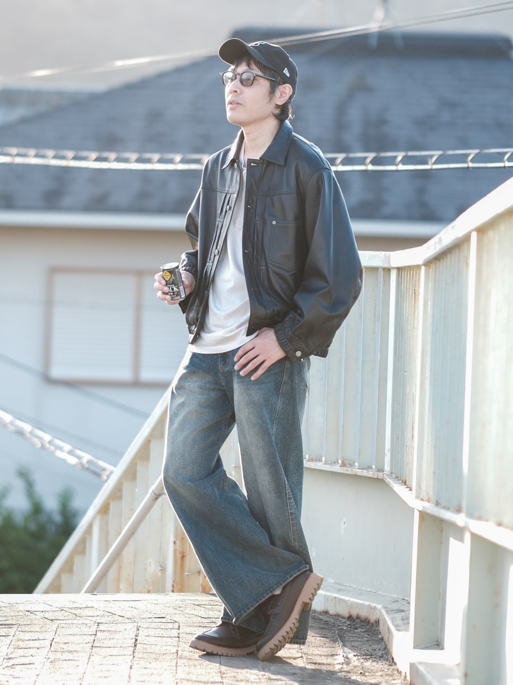 ホワイト系のTシャツ/カットソー、ブルー系のデニムパンツ、ブラック系のブルゾンを着用したメンズの秋コーディネートの1枚目の写真