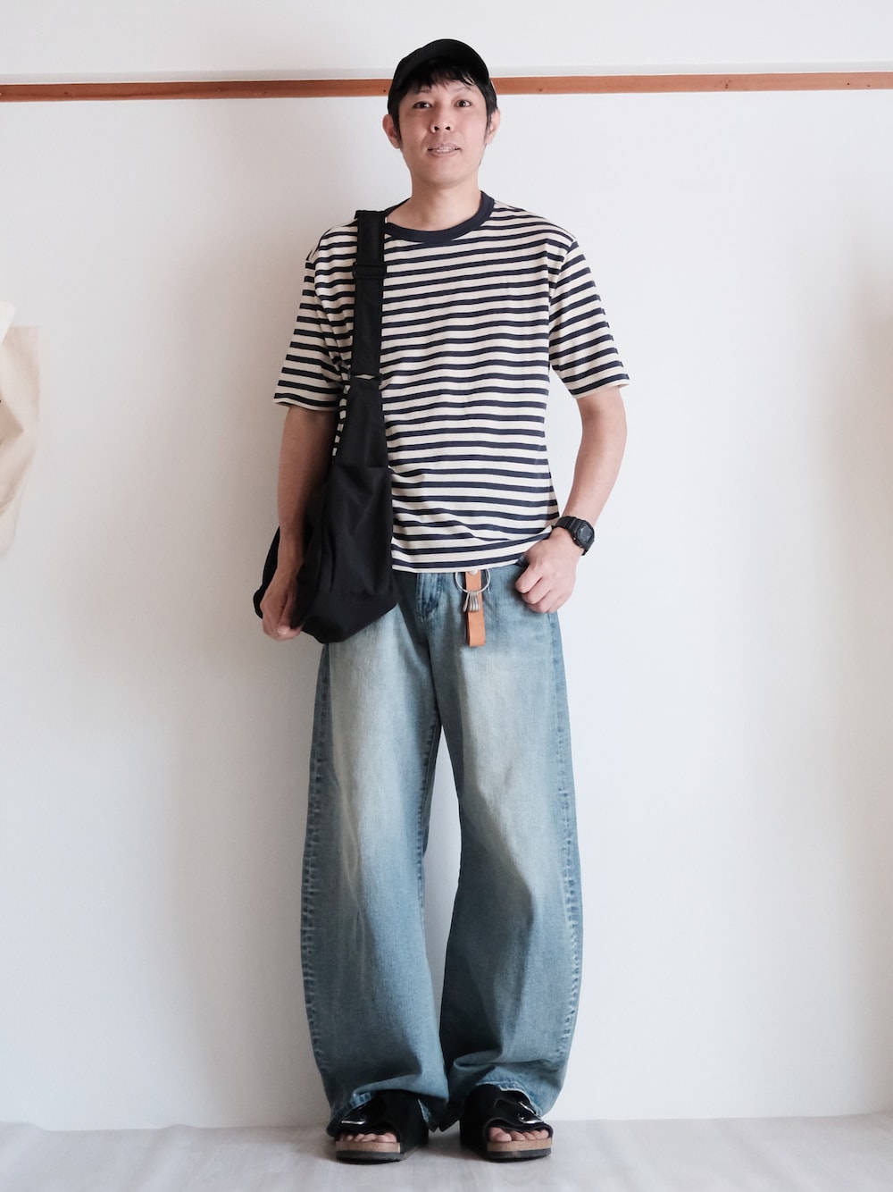 ブルー系のTシャツ/カットソー、ブルー系のデニムパンツ、ブラック系のショルダーバッグを着用したメンズの夏コーディネートの1枚目の写真