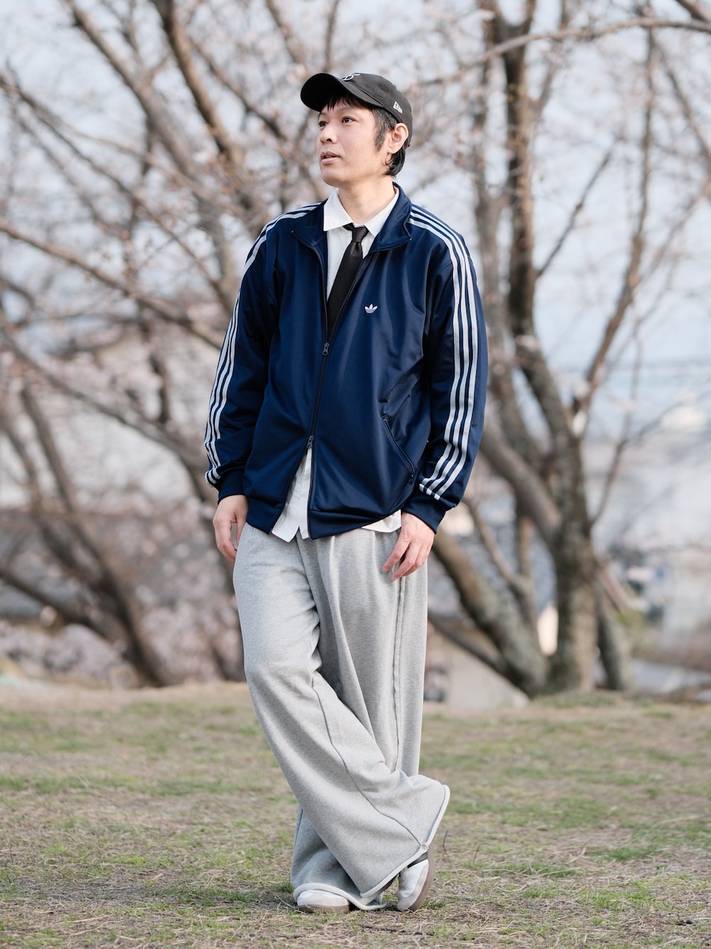 ブルー系のジャージ、グレー系のスウェットパンツ、ホワイト系のスニーカーを着用したメンズの春コーディネートの1枚目の写真