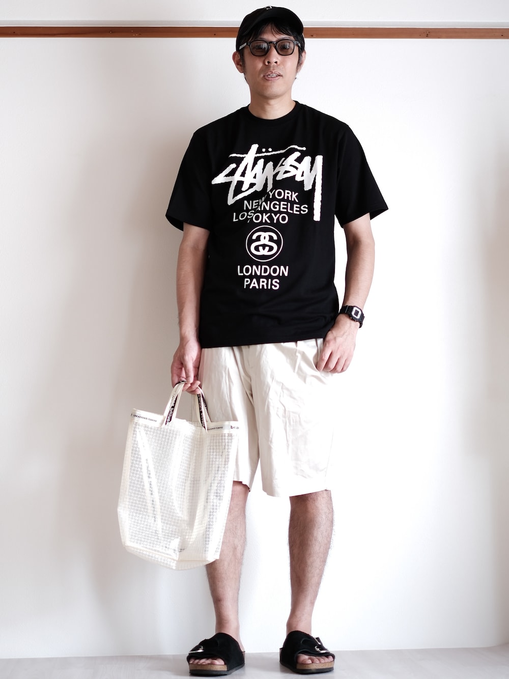 ブラック系のサンダル、ブラック系のTシャツ/カットソー、グレー系のサングラスを着用したメンズの夏コーディネートの1枚目の写真
