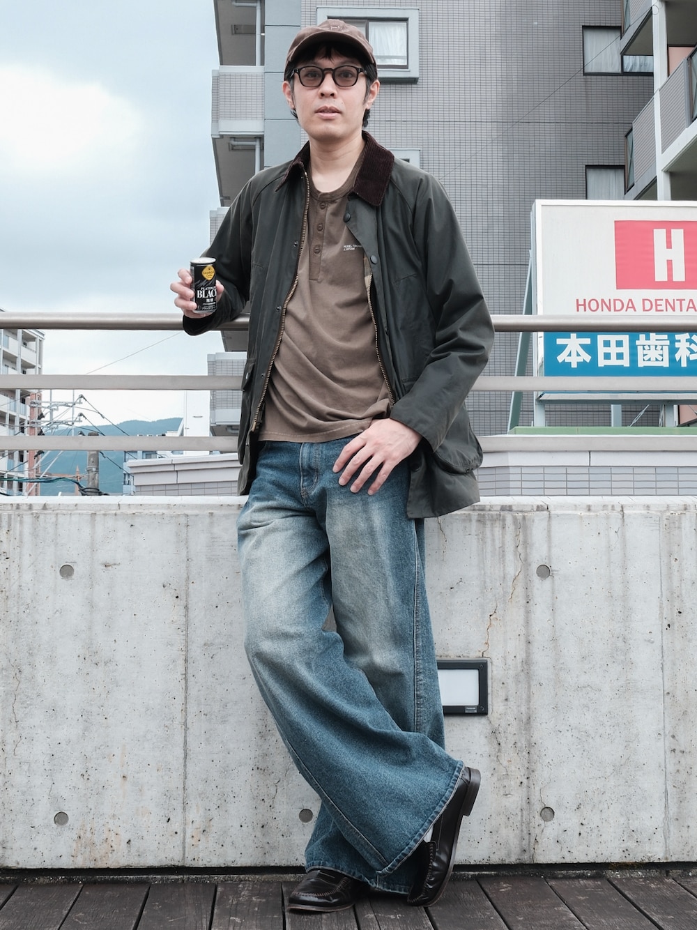 ブラウン系のTシャツ/カットソー、ブルー系のデニムパンツ、グリーン系のジャケット/アウターを着用したメンズの秋コーディネートの1枚目の写真
