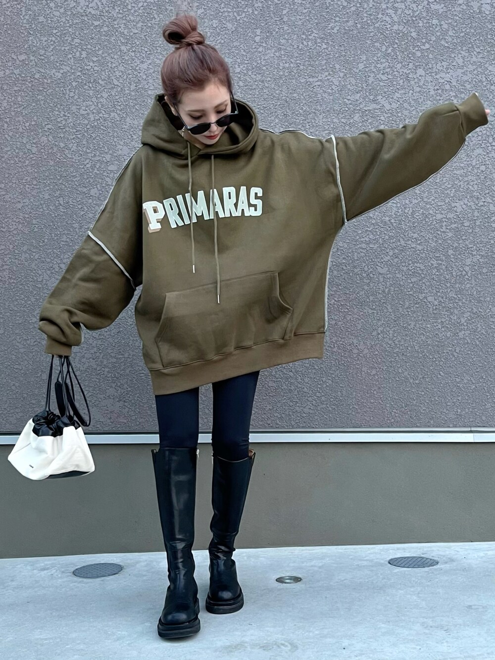 ブラック系のパーカー、ブラック系のその他パンツ、ブラック系のブーツを着用したレディースの秋コーディネートの1枚目の写真