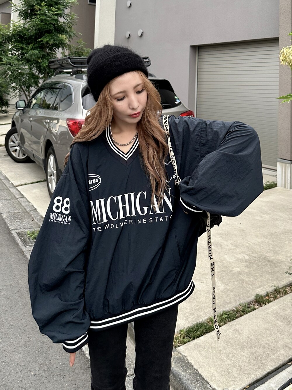 ブラック系のパーカー、ブラック系のデニムパンツ、ブラック系のボディバッグ/ウエストポーチを着用したレディースの秋コーディネートの1枚目の写真