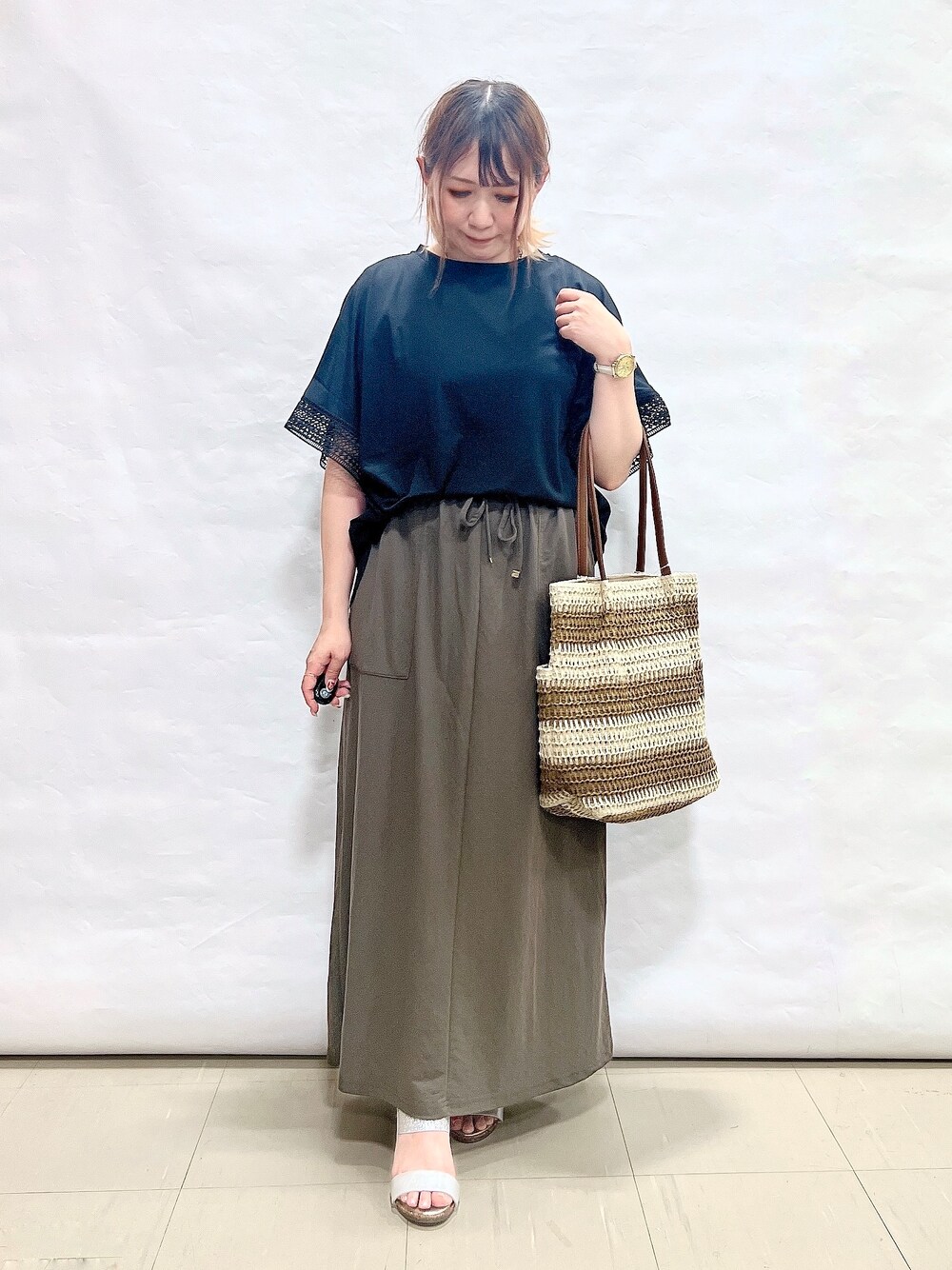 ブラック系のTシャツ/カットソー、グリーン系のスカート、シルバー系のサンダルを着用したレディースの夏コーディネートの1枚目の写真