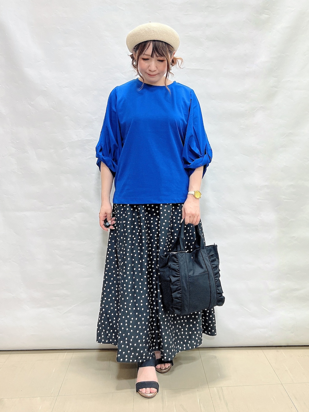 ブルー系のTシャツ/カットソー、ブラック系のスカート、ブラック系のサンダルを着用したレディースの夏コーディネートの1枚目の写真