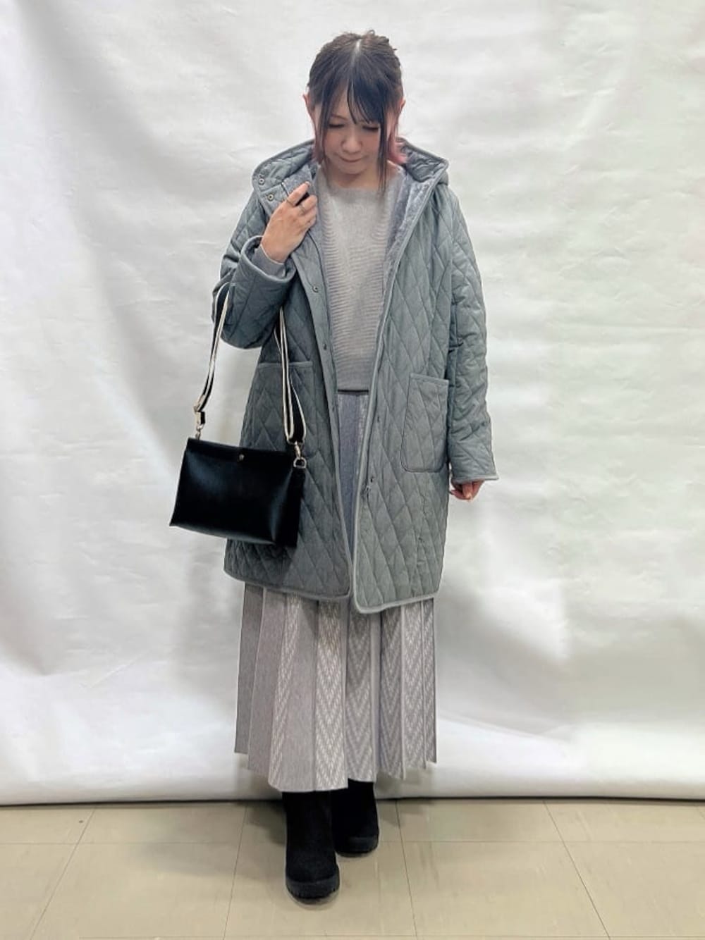 グレー系のその他アウター、グレー系のニット/セーター、グレー系のスカートを着用したレディースの冬コーディネートの1枚目の写真