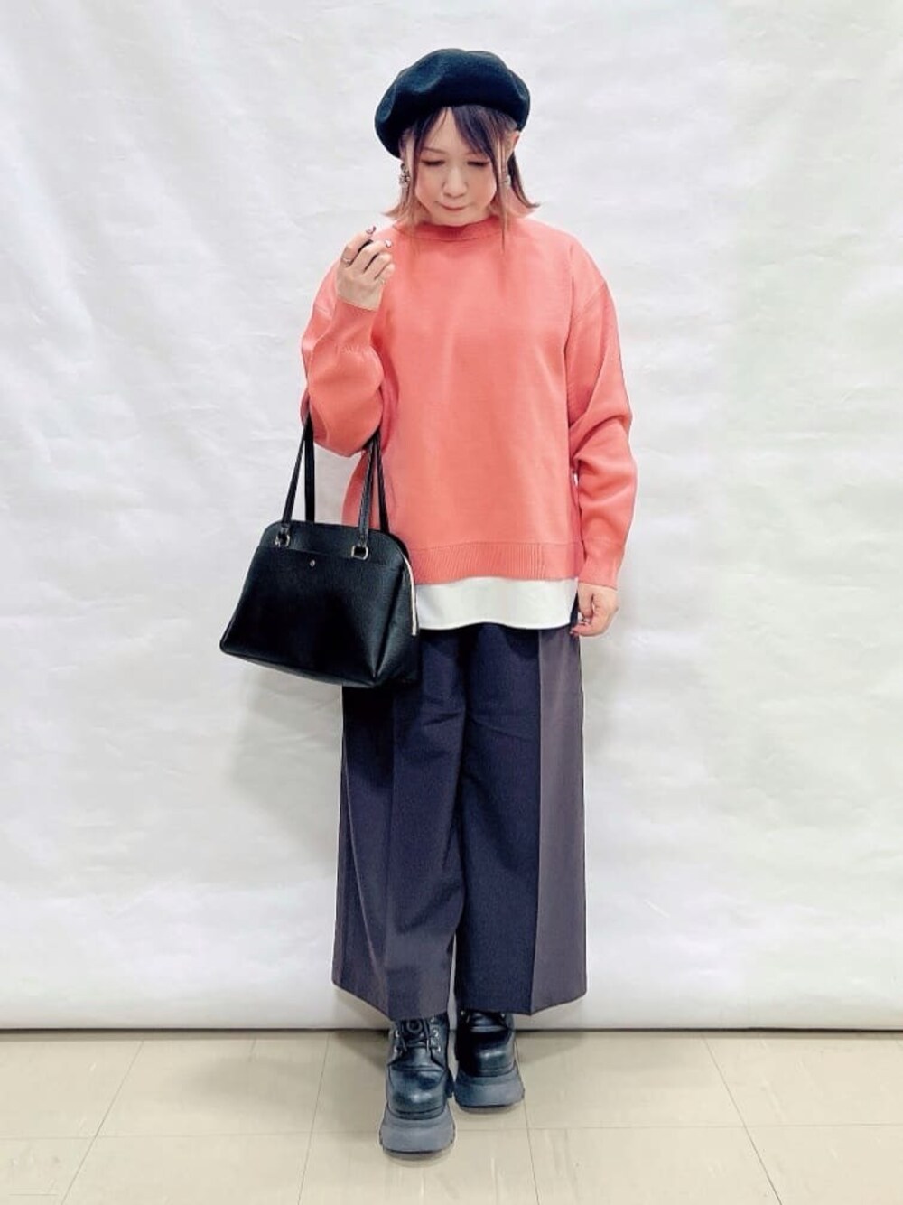 ピンク系のニット/セーター、ブラウン系のその他パンツ、ブラック系のショルダーバッグを着用したレディースの冬コーディネートの1枚目の写真