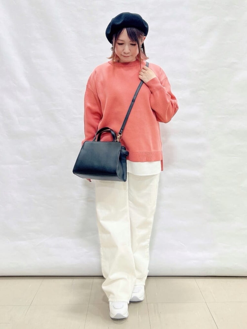 ピンク系のニット/セーター、ホワイト系のデニムパンツ、ホワイト系のスニーカーを着用したレディースの冬コーディネートの1枚目の写真