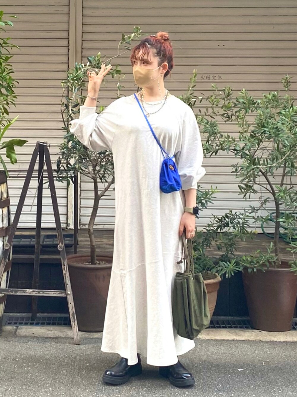 グレー系のワンピース、ブルー系のハンドバッグ、グリーン系のハンドバッグを着用したレディースの秋コーディネートの1枚目の写真