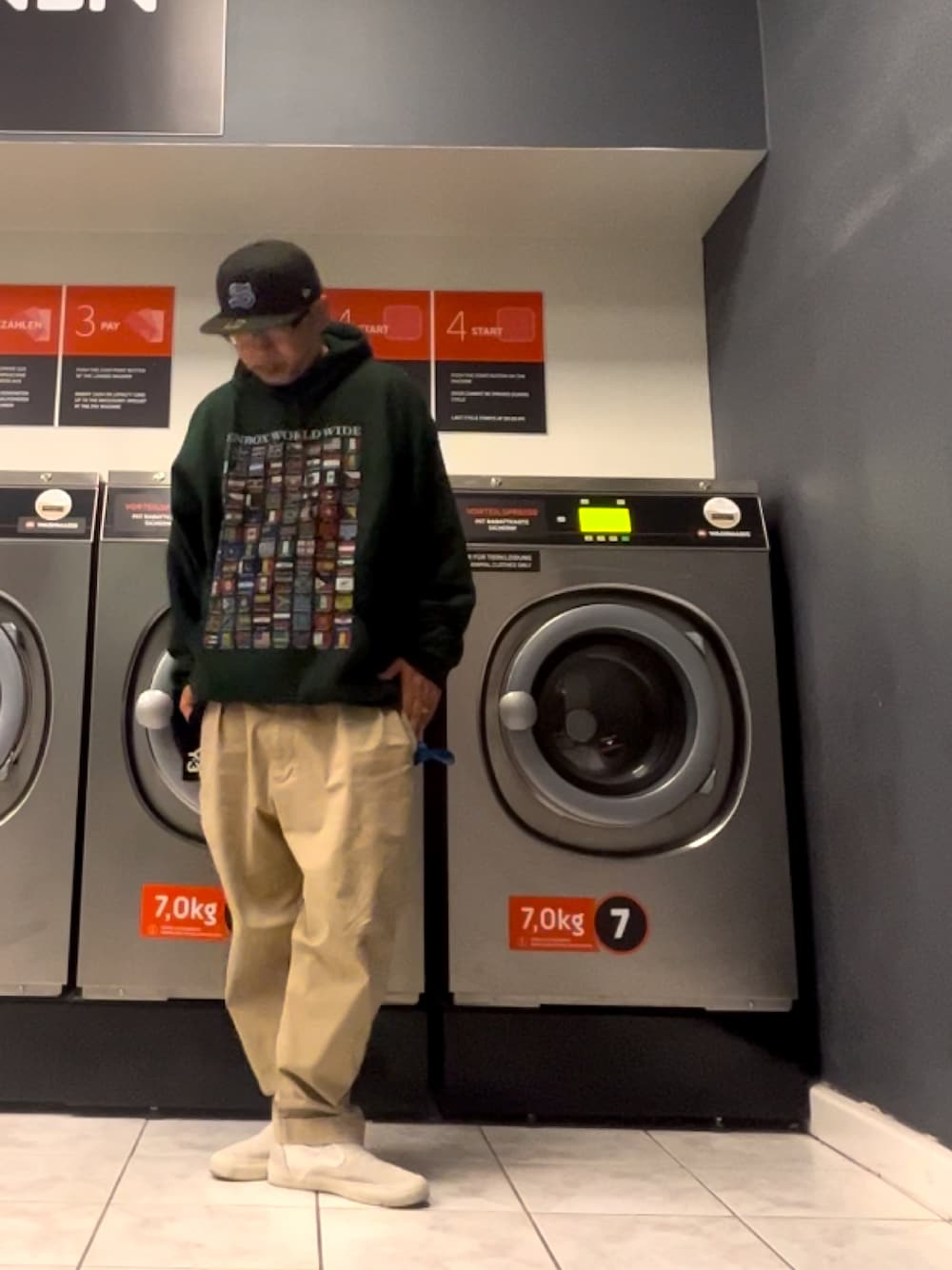 「キャップ、パーカー、チノパン、スリッポン、ドイツ、コインランドリー」｜「STUSSYのEmblem New Era Cap（キャップ、ブラック系）」を使った、＝＝トム＝＝さん（メンズ・174cm）の秋コーディネートの1枚目の写真