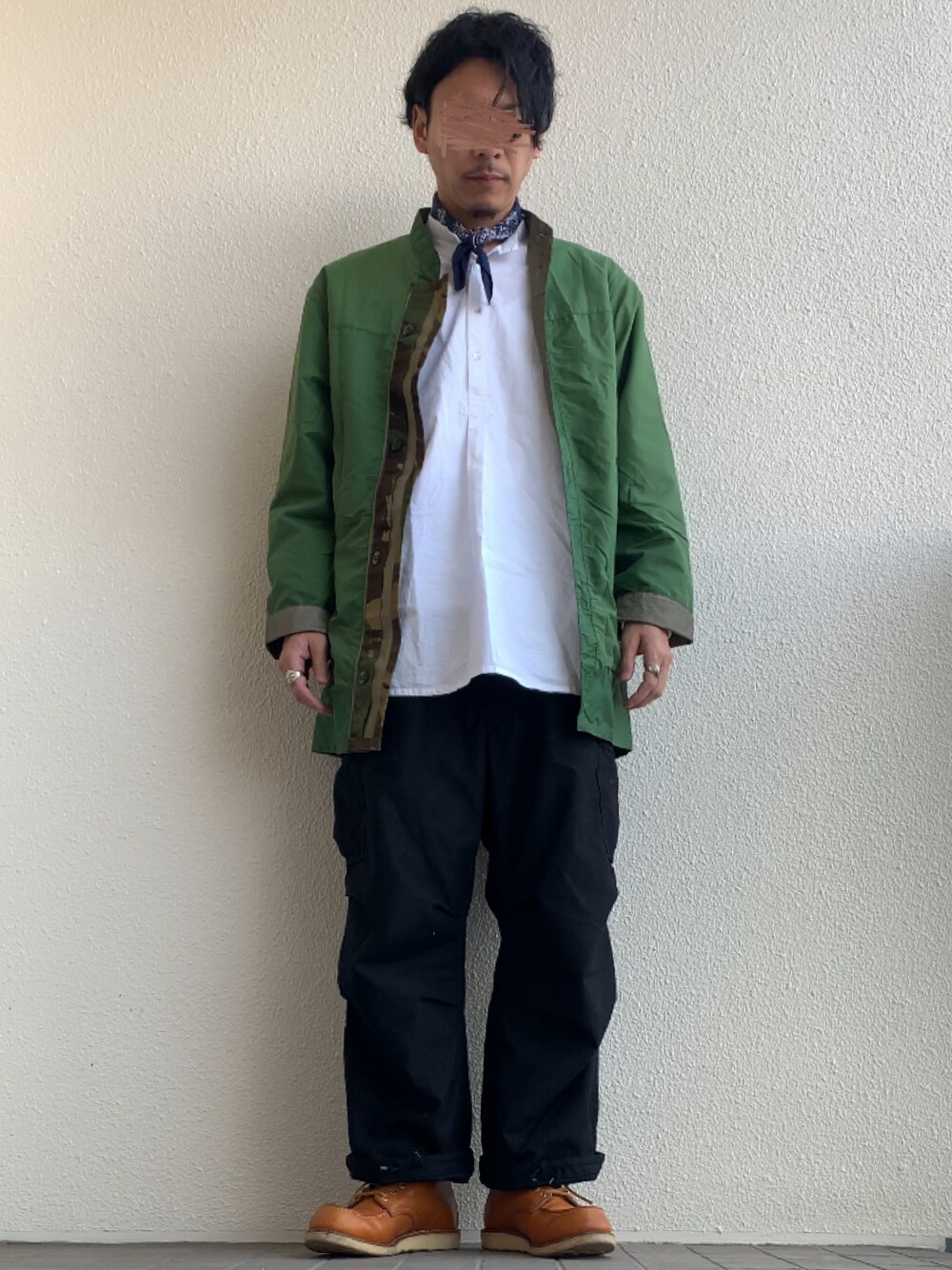 グリーン系のナイロンジャケット、ホワイト系のシャツ/ブラウス、ブラック系のカーゴパンツを着用したメンズの春コーディネートの1枚目の写真