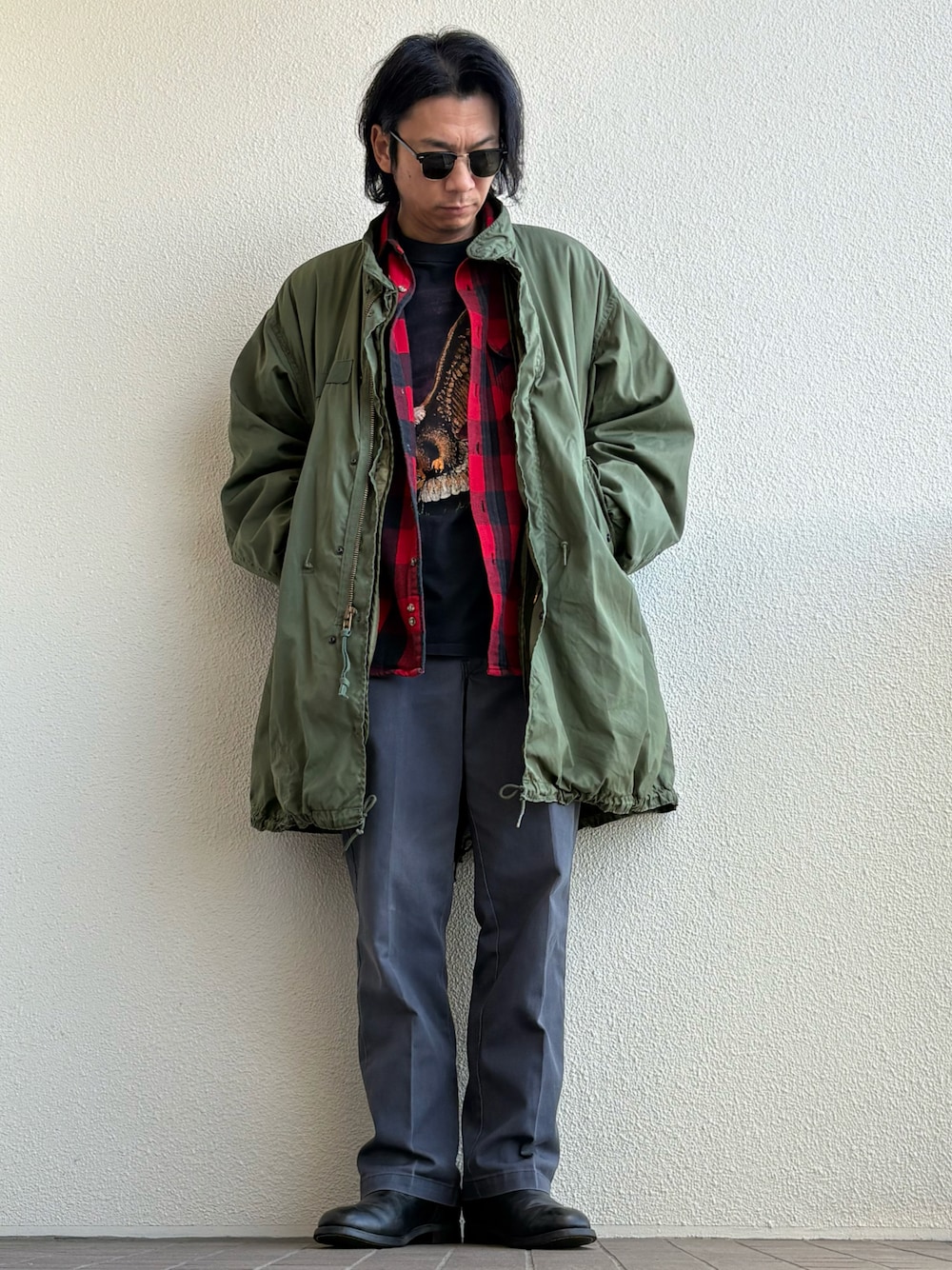 グリーン系のチノパンツ、グリーン系のモッズコート、ブラック系のサングラスを着用したメンズの冬コーディネートの1枚目の写真