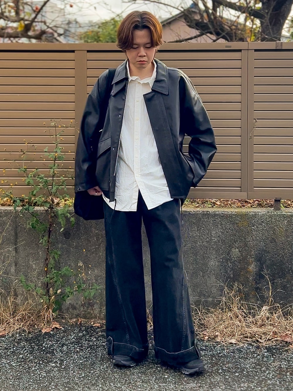 ブラウン系のブルゾン、ブラック系のスニーカー、ホワイト系のシャツ/ブラウスを着用したメンズの秋コーディネートの1枚目の写真