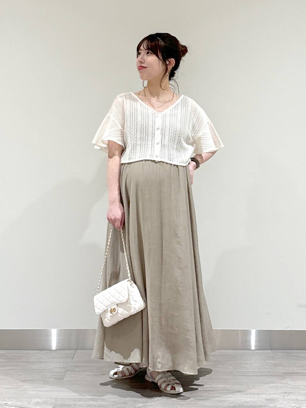 ホワイト系のカーディガン/ボレロ、グリーン系のワンピース、ホワイト系のショルダーバッグを着用したレディースの夏コーディネートの1枚目の写真