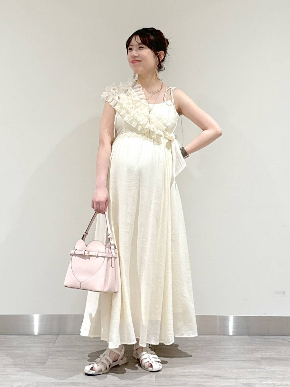 ホワイト系のワンピース、ピンク系のショルダーバッグを着用したレディースの夏コーディネートの1枚目の写真
