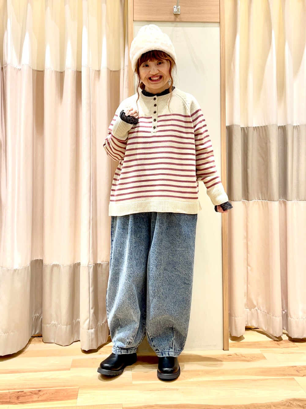 ピンク系のニット/セーター、グレー系のシャツ/ブラウス、ブルー系のデニムパンツを着用したレディースの冬コーディネートの1枚目の写真