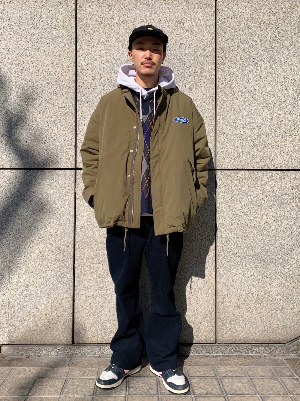 ブルー系のニット/セーター、グリーン系のモッズコート、ブラック系のその他パンツを着用したメンズの冬コーディネートの1枚目の写真