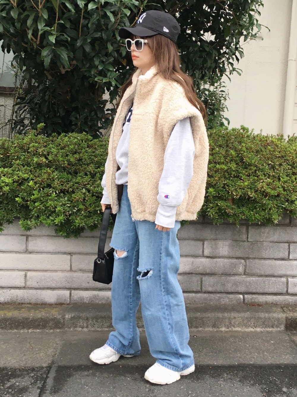 ベージュ系のトップス、ブルー系のパンツ、ホワイト系のスニーカーを着用したレディースの秋コーディネートの1枚目の写真