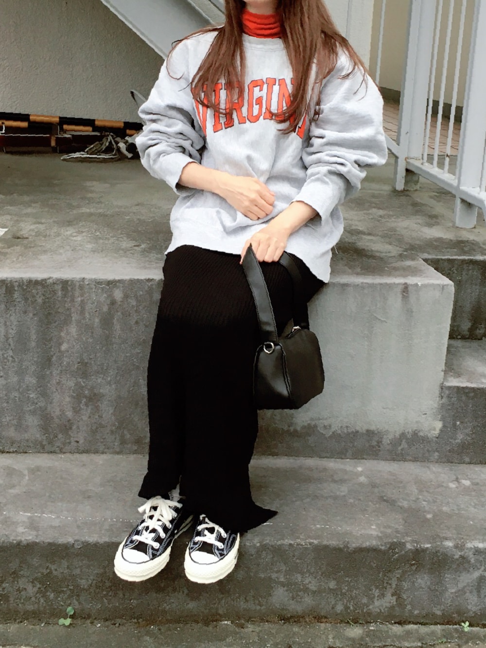 オレンジ系のTシャツ/カットソー、ブラック系のスカート、ブラック系のスニーカーを着用したレディースの秋コーディネートの1枚目の写真