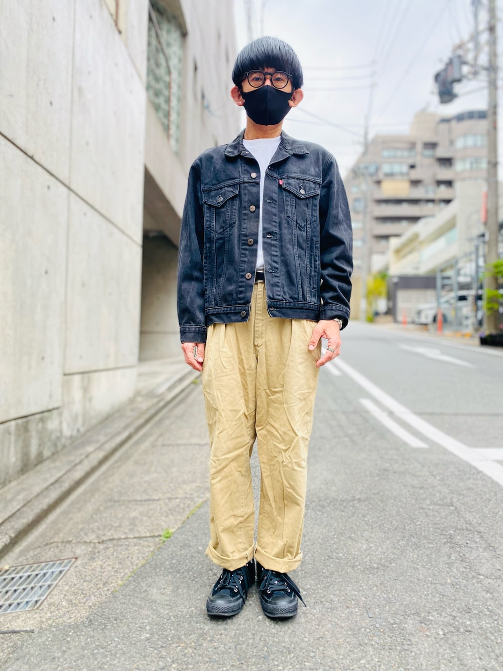 ブラック系のデニムジャケット、ホワイト系のTシャツ/カットソー、ベージュ系のチノパンツを着用したメンズの春コーディネートの1枚目の写真