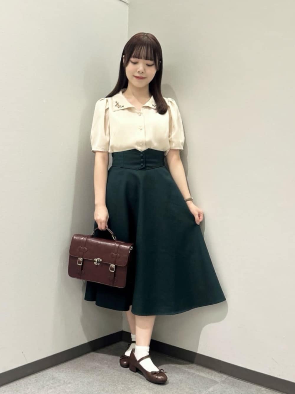 ブラウン系のショルダーバッグ、ベージュ系のシャツ/ブラウス、ブラウン系のバレエシューズを着用したレディースの秋コーディネートの1枚目の写真