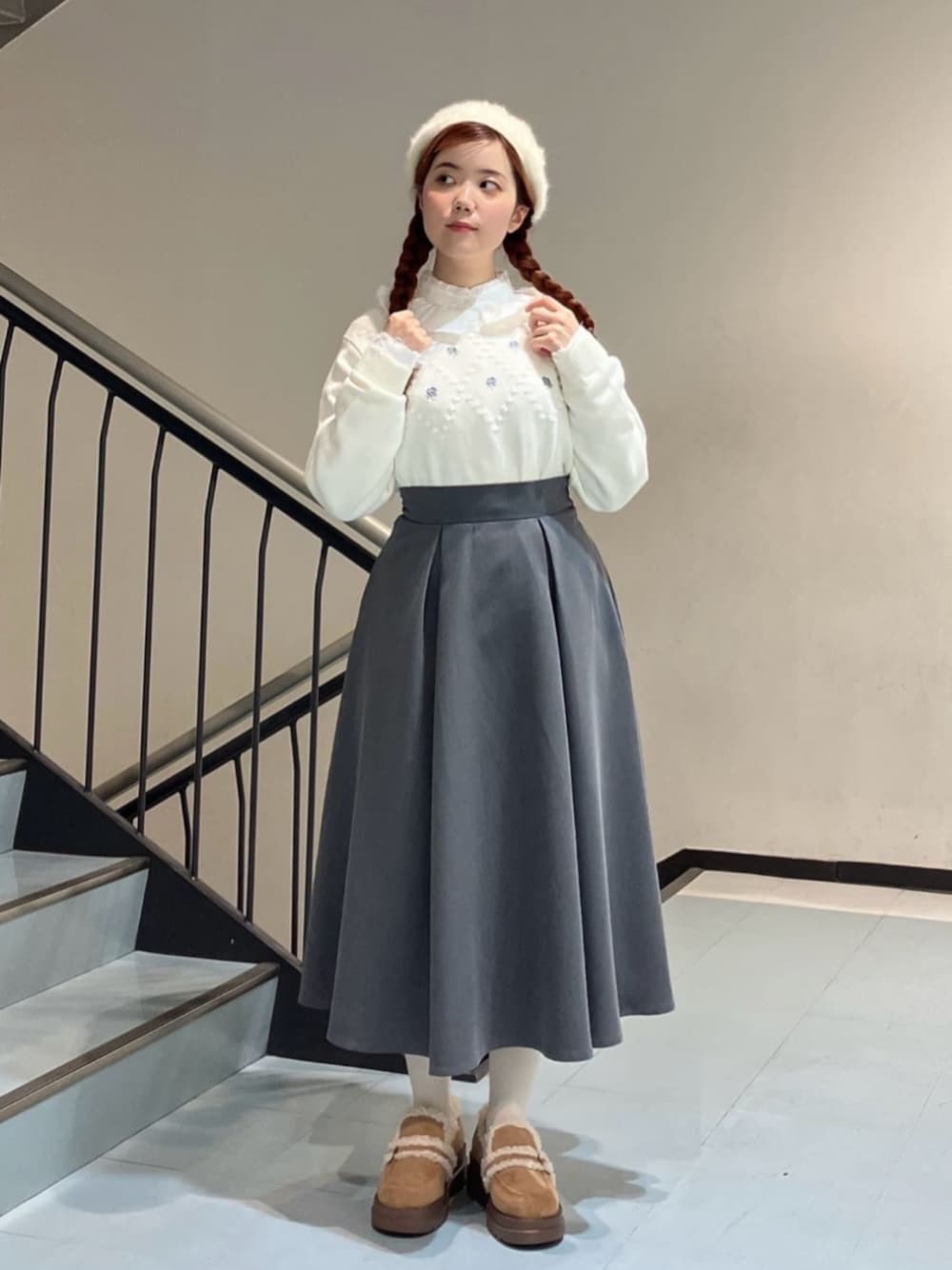 ホワイト系のシャツ/ブラウス、ベージュ系のモカシン/デッキシューズ、グレー系のスカートを着用したレディースの冬コーディネートの1枚目の写真