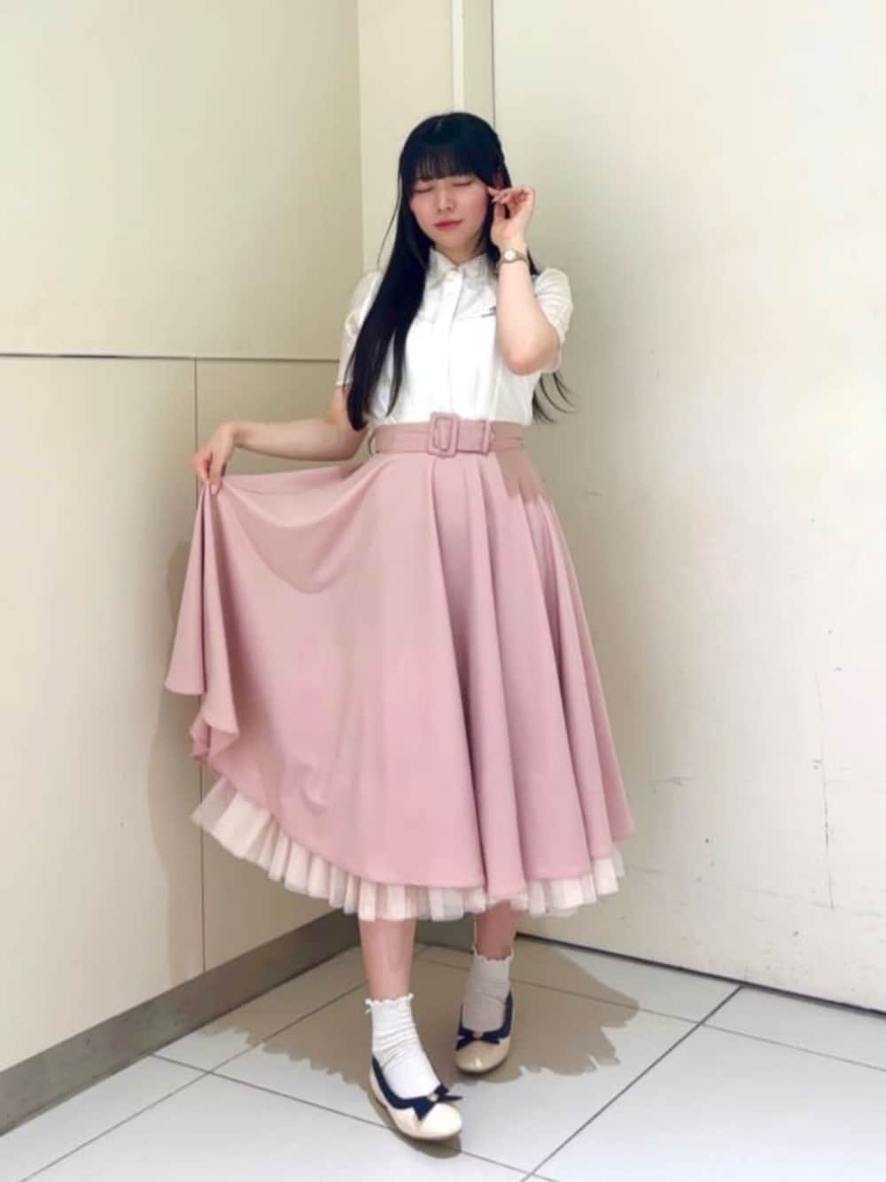 ピンク系のスカート、ホワイト系のシャツ/ブラウス、ホワイト系のパンプスを着用したレディースの春コーディネートの1枚目の写真