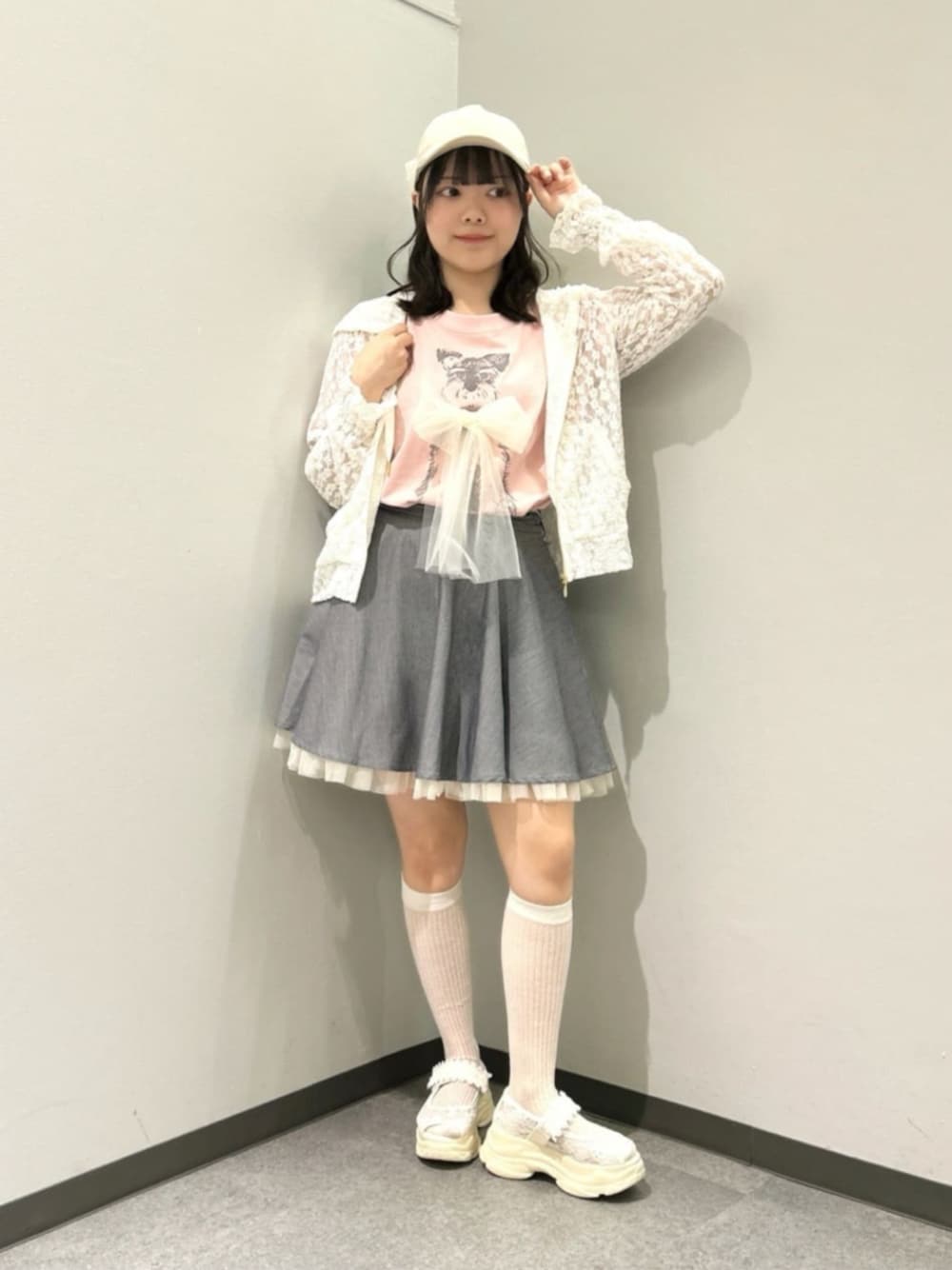 グレー系のスカート、ホワイト系のパーカー、ホワイト系のサンダルを着用したレディースの春コーディネートの1枚目の写真