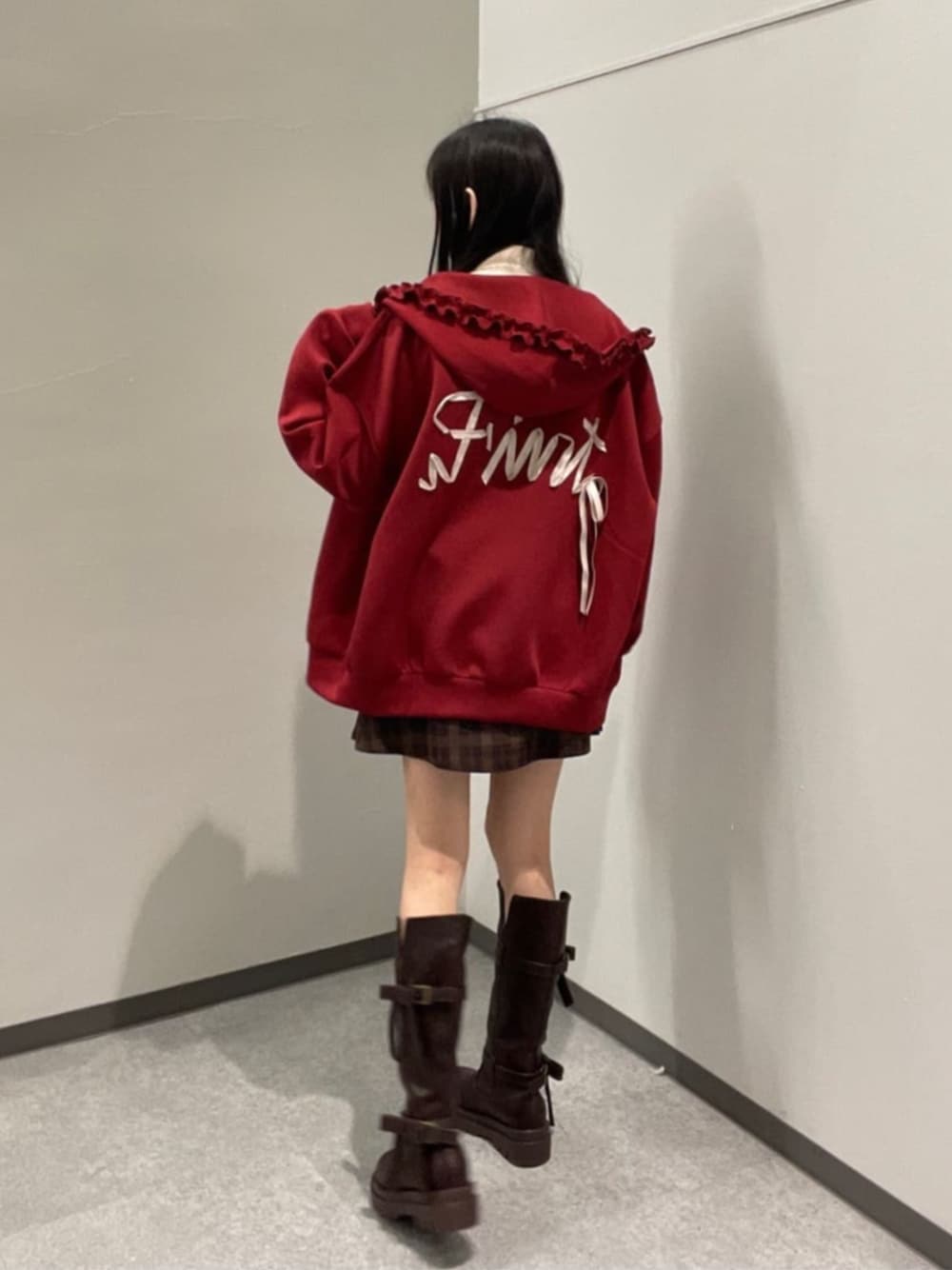 ブラウン系のスカート、レッド系のパーカー、ブラウン系のブーツを着用したレディースの秋コーディネートの1枚目の写真