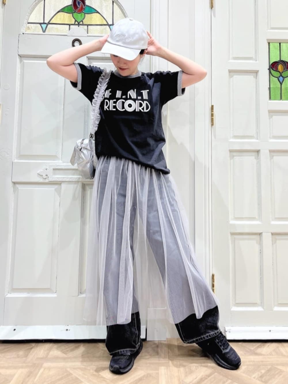 ブラック系のTシャツ/カットソー、グレー系のスカート、ブラック系のデニムパンツを着用したレディースの春コーディネートの1枚目の写真