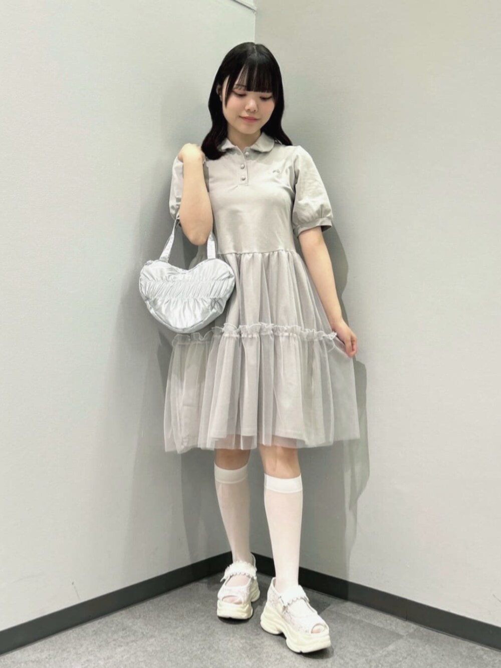 ホワイト系のスニーカー、グレー系のワンピースを着用したレディースの夏コーディネートの1枚目の写真