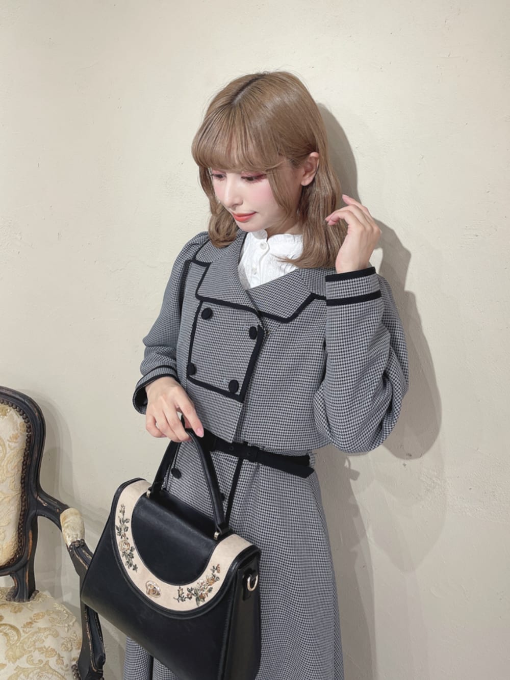 ホワイト系のシャツ/ブラウス、ブラック系のセットアップ、ブラック系のハンドバッグを着用したレディースの秋コーディネートの1枚目の写真