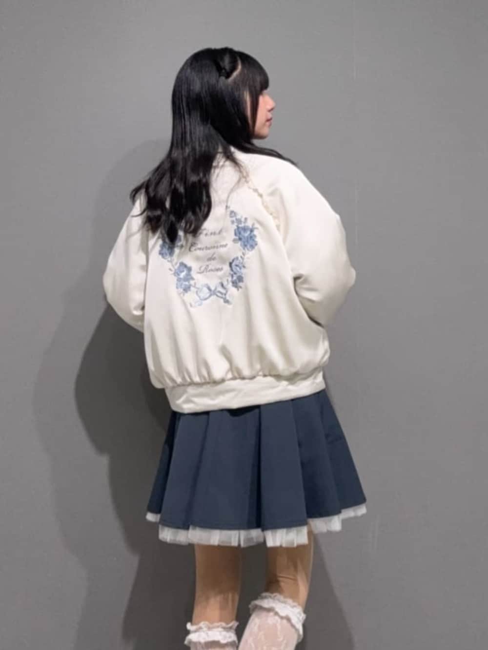 ブルー系のスカート、ホワイト系のシャツ/ブラウス、ホワイト系のブルゾンを着用したレディースの冬コーディネートの1枚目の写真