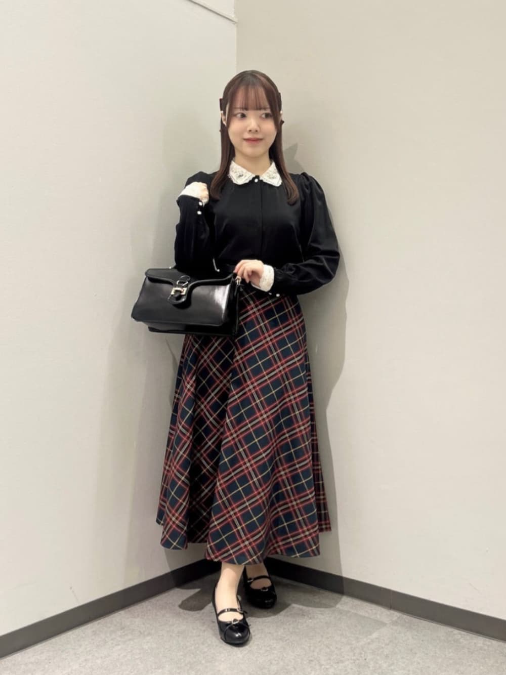 ブラック系のハンドバッグ、ブラック系のパンプス、ブラック系のシャツ/ブラウスを着用したレディースの冬コーディネートの1枚目の写真