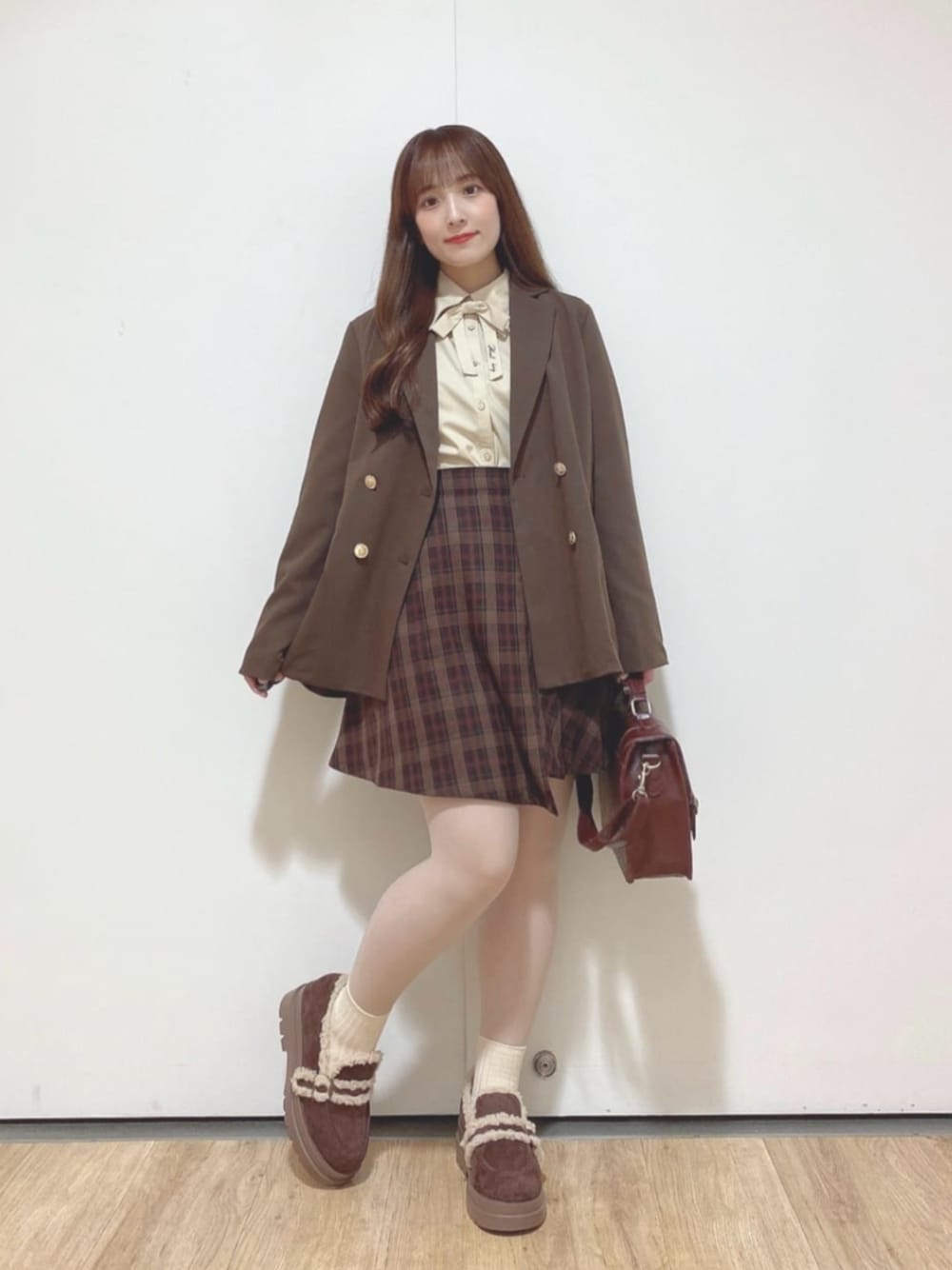 ブラウン系のショルダーバッグ、ベージュ系のシャツ/ブラウス、ブラウン系のスカートを着用したレディースの秋コーディネートの1枚目の写真