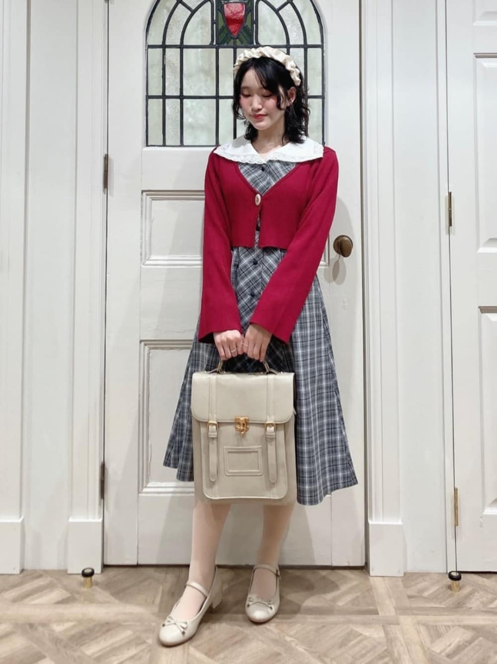 ベージュ系のパンプス、ベージュ系のハンドバッグ、ブラック系のワンピースを着用したレディースの春コーディネートの1枚目の写真