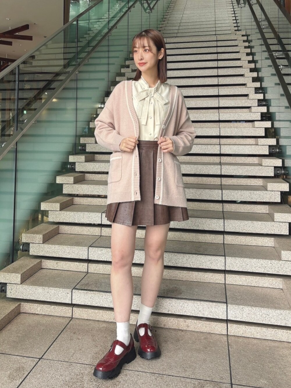 「fint、an another angelus、骨格ウェーブ、イエベ春、お出かけコーデ、秋コーデ、秋のコーデ、秋冬コーデ、カーディガン、ボウタイブラウス、リボン、レザー、プリーツスカート、ブラウン、厚底シューズ」｜「F i.n.tのキルト風フェイクレザーミニスカート（スカート、ブラウン系）」を使った、F i.n.tさん（レディース・165cm）の秋コーディネートの1枚目の写真